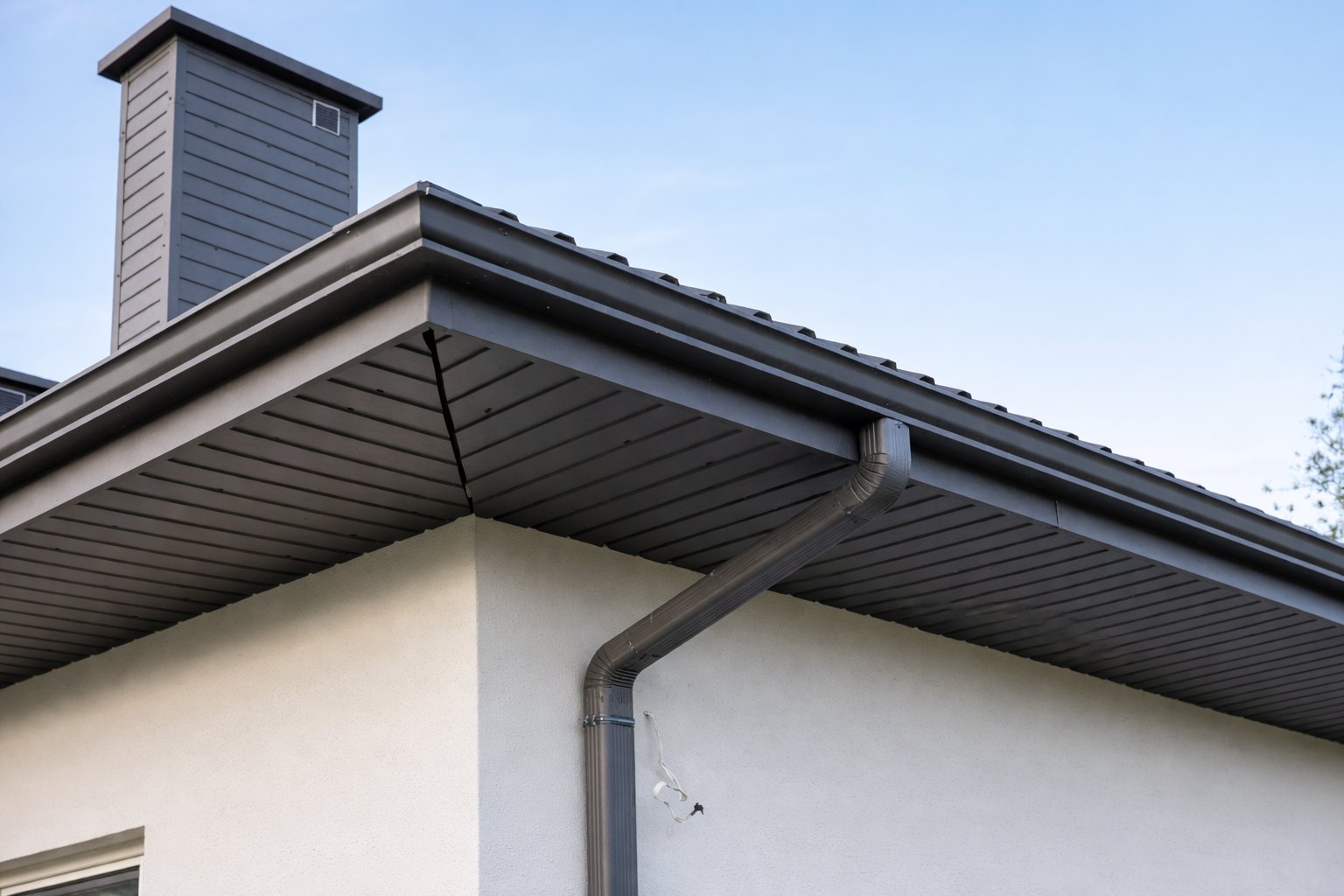 Металлическая прямоугольная водосточная система на строительном объекте